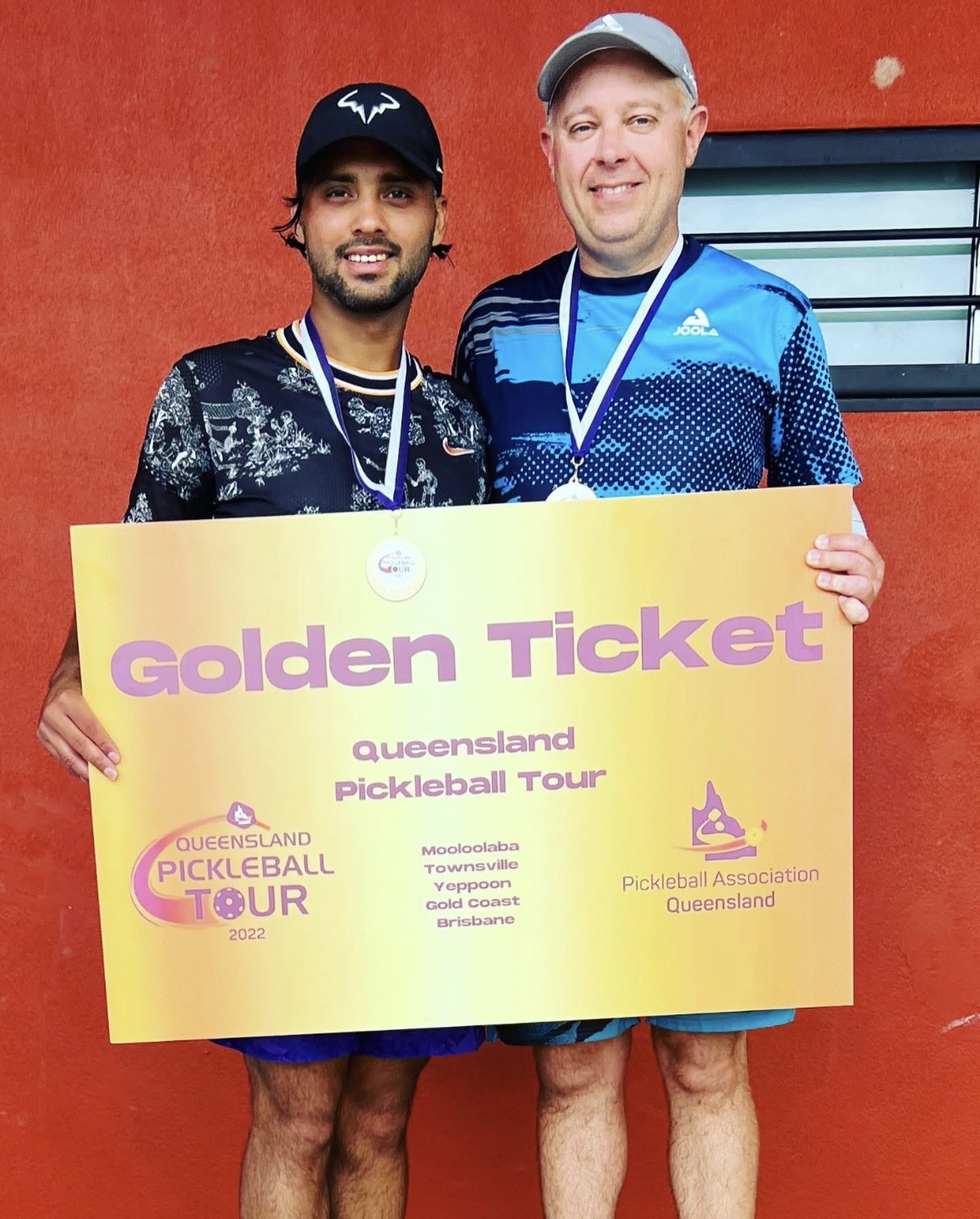 Sueme Rajpal displaying 'golden ticket' and gold medal with partner David Richardson after winning Queensland Pickleball Tour 2022 men's doubles division.