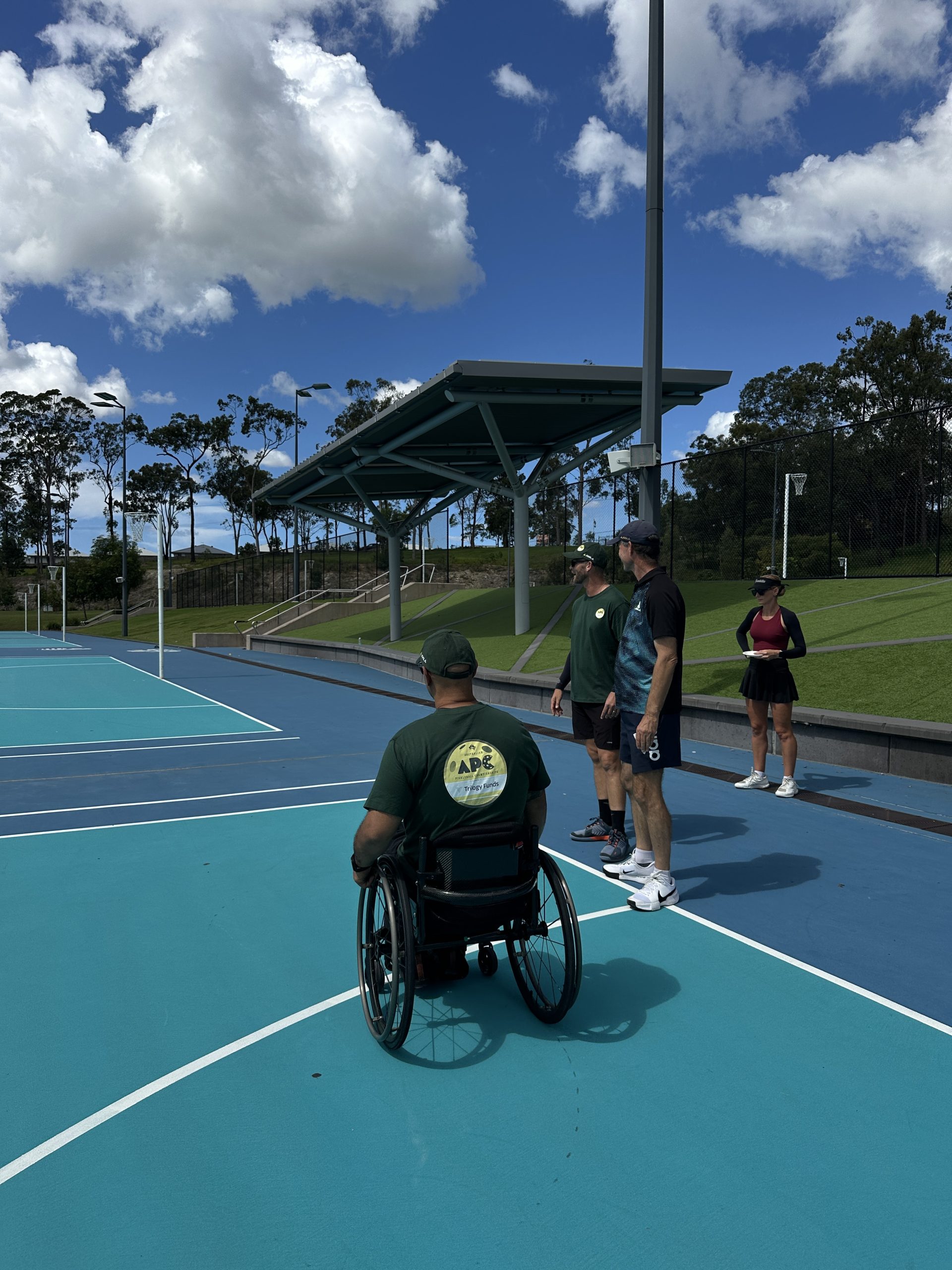 Shannon Burr, Adrian Gray, Sarah Burr, and Dion Reweti at the Pimpama Sports Hub netball courts that will be converted to pickleball courts for the 2025 Australian Pickleball Championships.